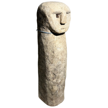 Podlouhlá kamenná soška s jemně vytesaným obličejem na jednom konci.