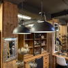 Závěsná kovová lampa v šedé barvě s jednoduchým, zakulaceným designem, který dodává prostoru minimalistický a moderní vzhled.